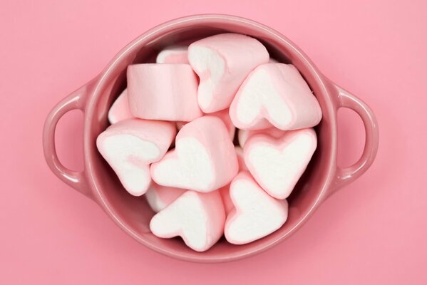 In einer Tasse sind Marshmallows in Form von Herzen verteilt