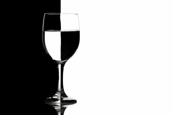 Immagine in bianco e nero di un bicchiere di vino con liquido trasparente