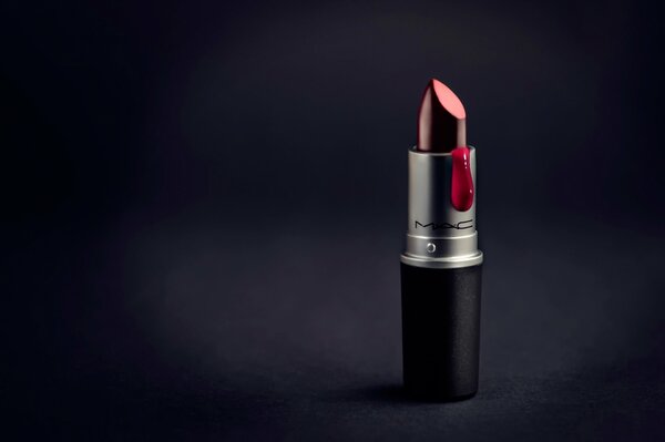 Lipstick on a black background with a drop