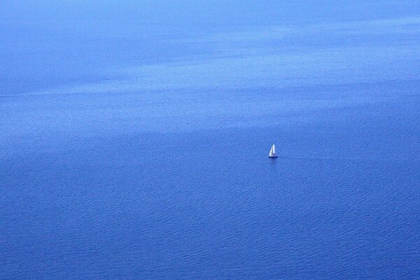 Samotna żaglówka na błękitnym morzu