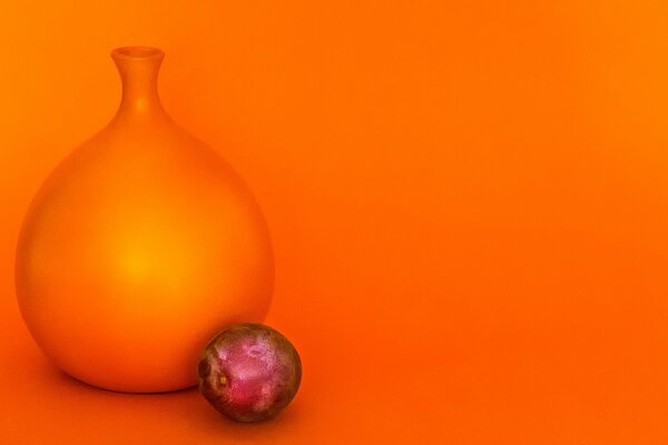 Jug and plum on a bright orange background