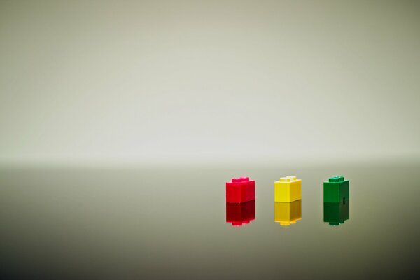 Tre mattoncini LEGO di colore rosso, giallo e verde