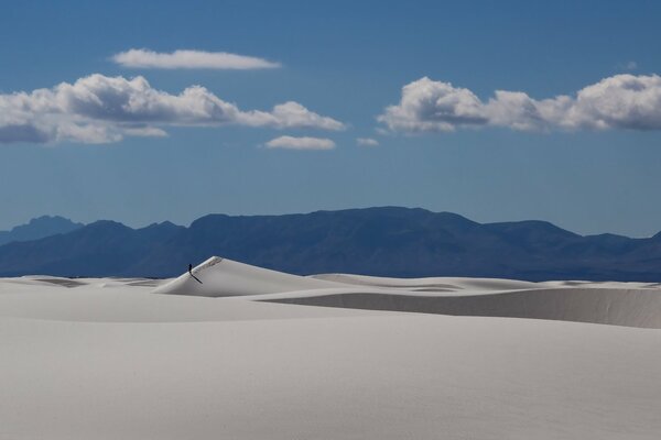 Desert landscape. Sands and mountains on the horizon. A man walks in the desert