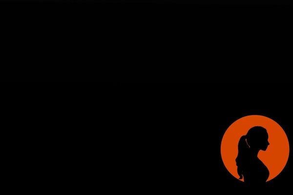 Silhouette of a girl on a dark background in an orange circle