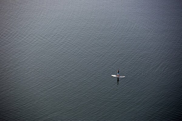 A man on a canoe in the open sea