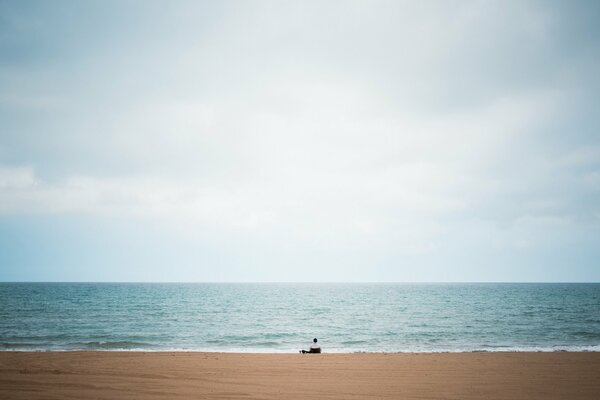 Hombre solitario en la playa de arena