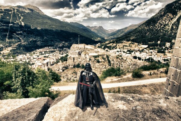 Darth Vader con una espada en el fondo de la ciudad vieja y la cordillera