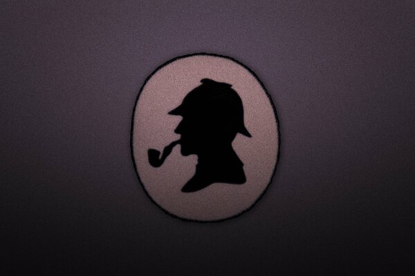 A medallion with a silhouette of Sherlock Holmes with a pipe