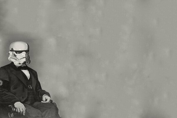 A man on a chair wearing a stormtrooper mask on a gray background