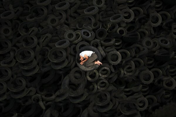 The guy fell asleep in the tire. mountain of tires