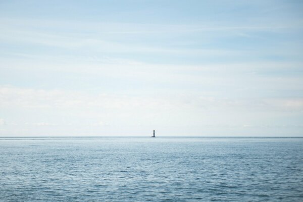 The lighthouse is visible on the horizon of the sea