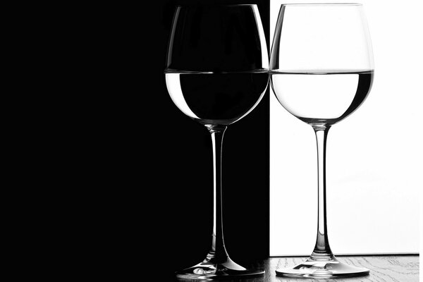 Glasses on a black and white background stand on a wooden table