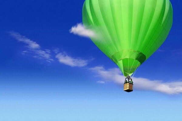 A bright balloon on a background of blue sky and white clouds