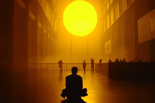 Homme regardant le soleil de taille inhabituelle