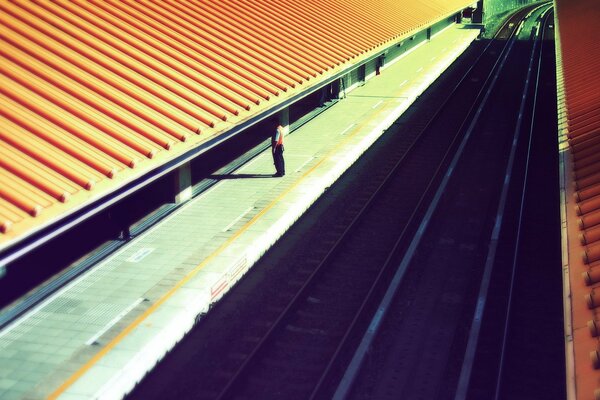 Uomo sul piazzale, ferrovia