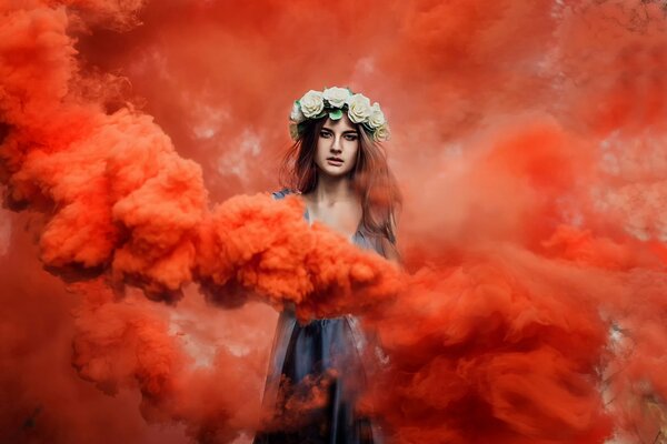 A girl with a wreath on her head in red smoke