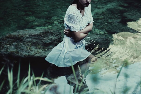 Servizio fotografico in acque tranquille, ragazza in abito bianco