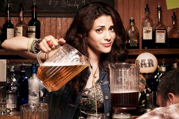 Belle fille traite une bière dans un bar