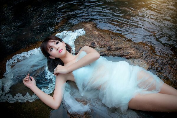 A girl in a white dress on a stone