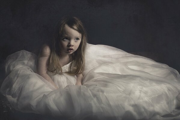 A girl in a long white dress on the floor