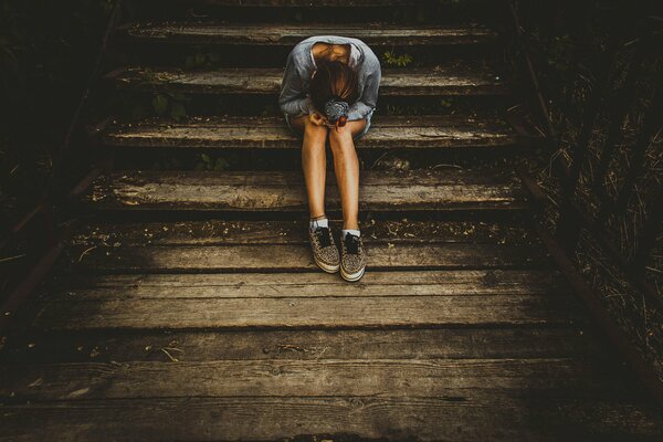 Chica llorando en las escaleras