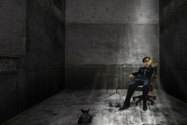 Policjant na krześle biurowym z czarnym telefonem w bunkrze