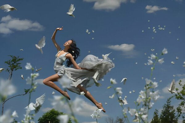 Ragazza con colombe sullo sfondo del cielo