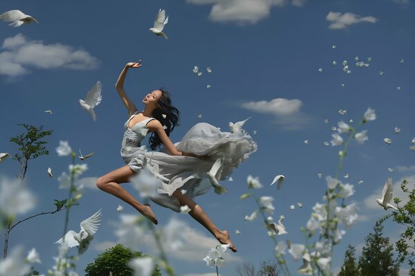 Dziewczyna z gołębiami na tle nieba