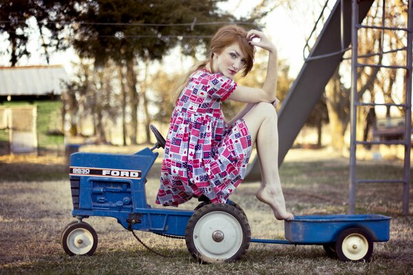 A girl on a children s blue tractor