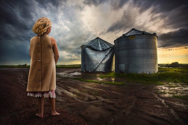 The consequences of a tornado. Barefoot girl after the storm