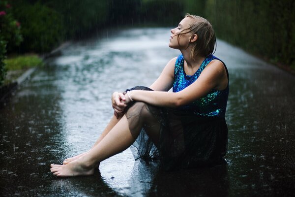 La jeune fille en robe bleue sous la pluie