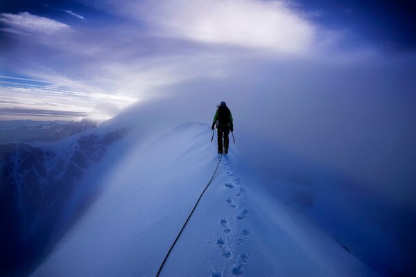 A climber walks through snow-covered mountains