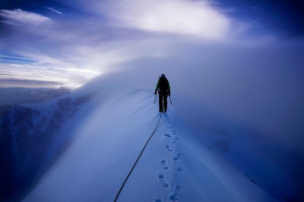 Scalatore che cammina su montagne innevate