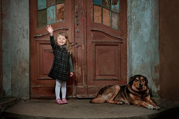 Mała dziewczynka z psem przy drzwiach
