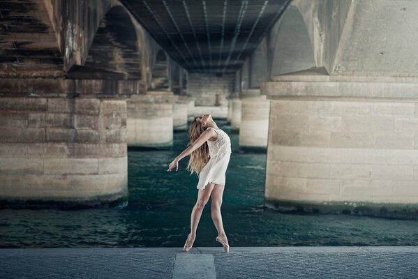 Anmutige Ballerina tanzt unter der Brücke