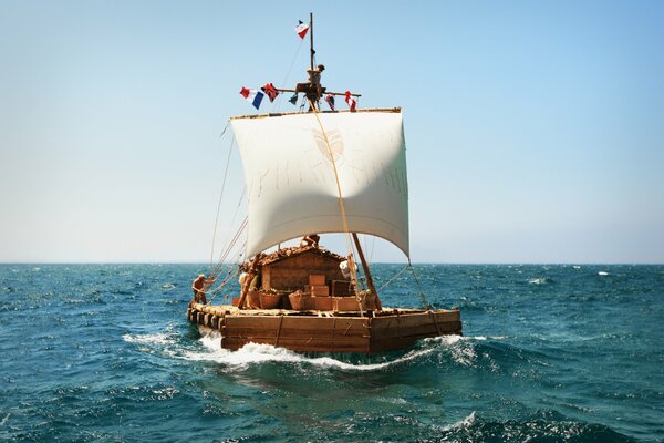 A raft with a white sail in the blue sea