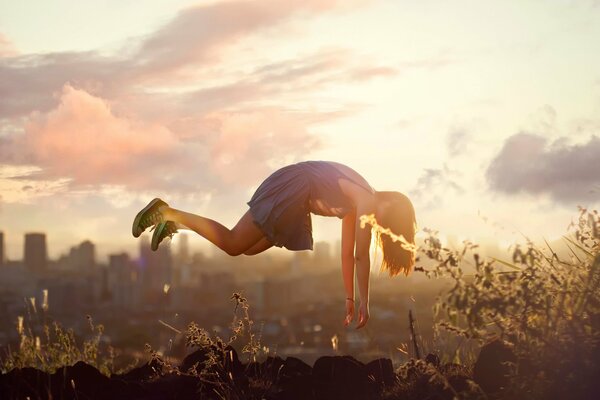 Kylie Woon levitates in the air against the background of the city