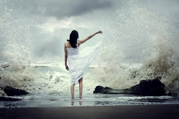 La jeune fille en robe blanche, debout sur le de la mer