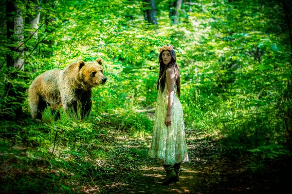 Chica en vestido en el bosque con un oso