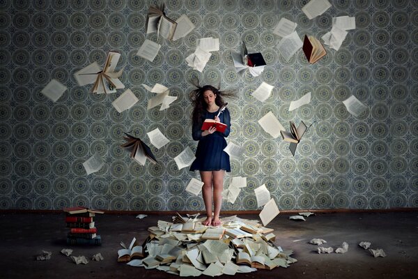 A girl in an empty room with flying book leaves