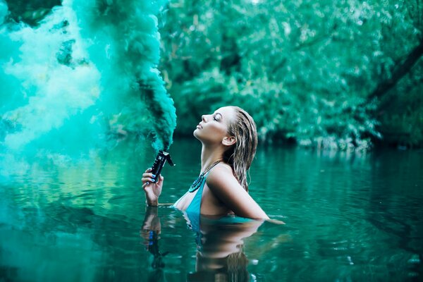 La jeune fille dans le lac de laisser la fumée verte