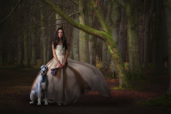 A girl in a beautiful dress with a bouquet of flowers and a dog