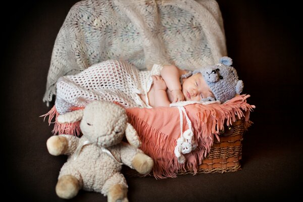 Bébé nouveau-né dans un bonnet mignon dort dans un panier