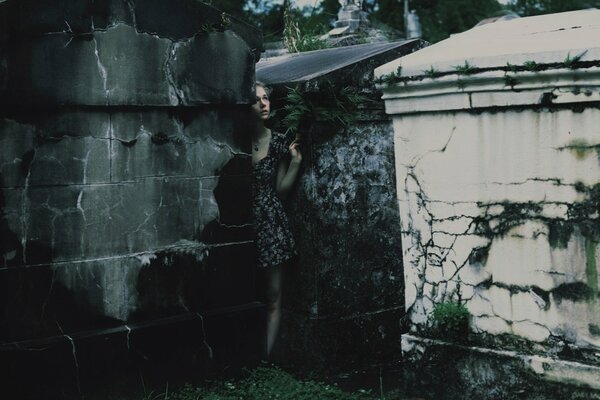 A girl walks in the cemetery near the crypts