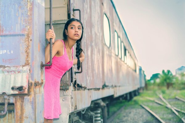 La mirada de una chica en un vestido rosa. Chica en el tren