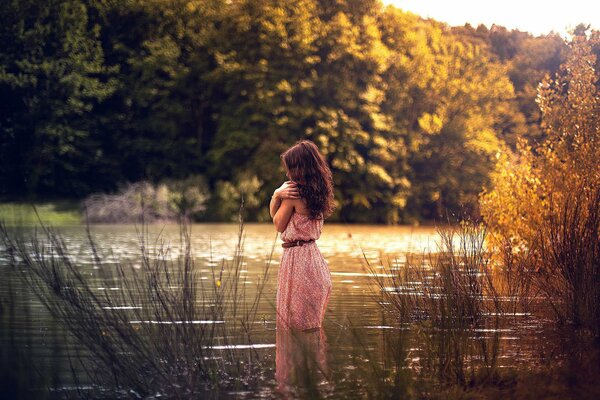 Mädchen im rosa Kleid im Wasser