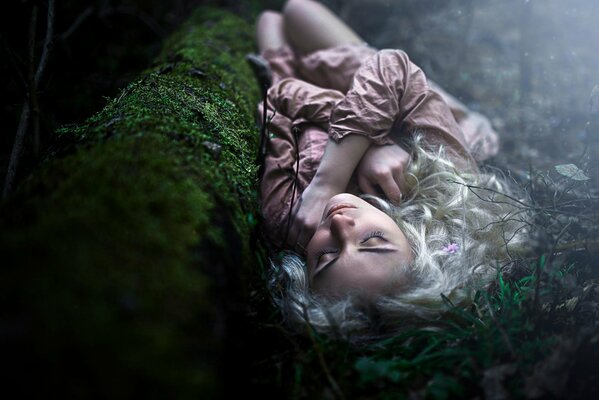 Blonde girl sleeping in the woods