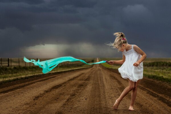 La ragazza cammina sulla strada per la tempesta