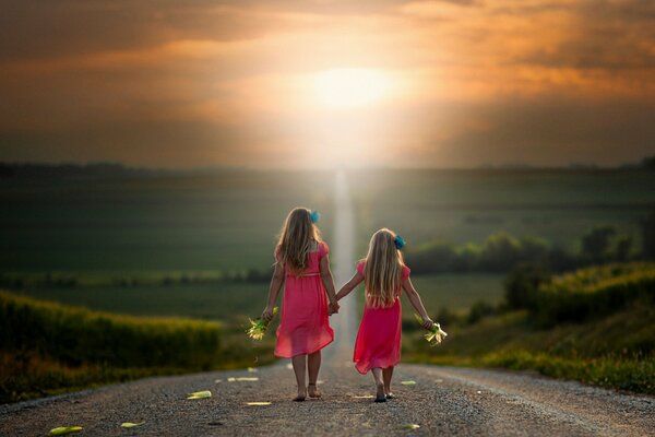 Les deux filles vont se tenant par la main sur la route