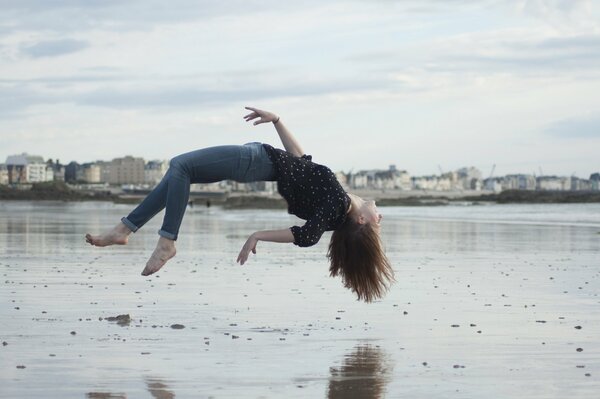 Girl on the beach in the city , levitation